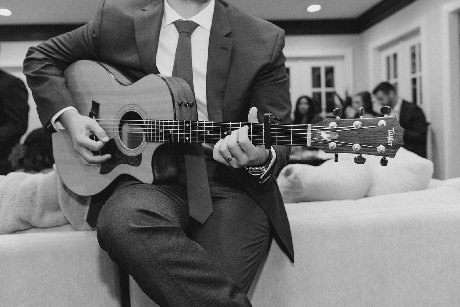 Me playing an acoustic guitar while leaning on a couch